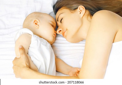 Mother And Baby Sleeping On The Bed Together