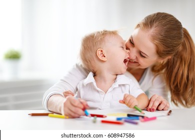 Mother and the baby son and colored pencils   laugh