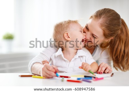 Mother with the baby son with colored pencils and laugh