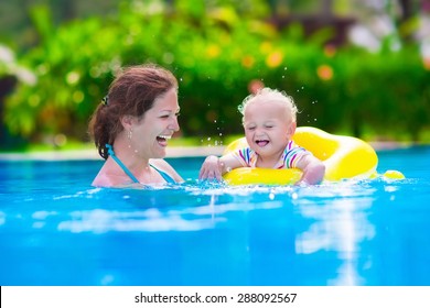 Mother And Baby In Swimming Pool. Parent And Child Swim In A Tropical Resort. Summer Outdoor Activity For Family With Kids. Vacation And Traveling With Young Children. Inflatable Toys For Water Fun.