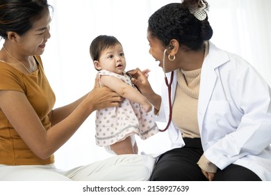 Mother And Baby Visit To The Doctor Using Stethoscope Checking Heart Beat