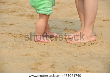 mother and baby walking on beach 