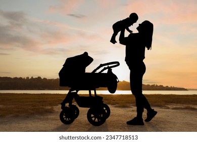 Mother with baby walking outdoors at sunset, silhouette - Powered by Shutterstock