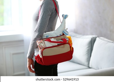 Mother With Bag For Baby At Home