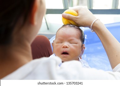 Mother Bathing Child In A Bathroom.