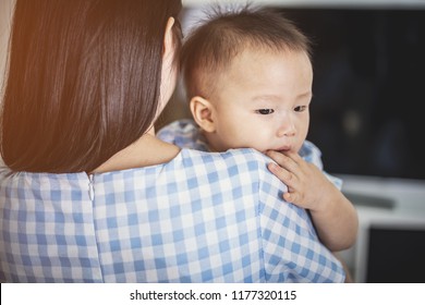 Mother From Behind Holding Crying Asian Baby Boy, Mom Comforting His Baby Boy.