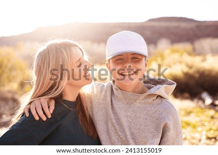 Mother being playful with her cute teenage son. Having a happy moment together. Concept photo about parenting tough teenage children. Candid photo	
