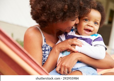 Mother bonding with young son sitting in a hammock - Powered by Shutterstock