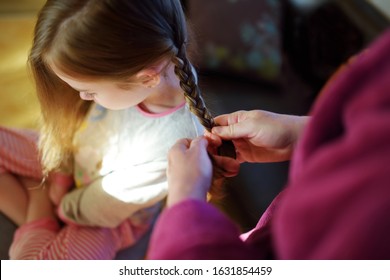 Mother Braiding Her Little Daughters Hair In The Morning. Beautiful Little Girl Getting Ready For School.