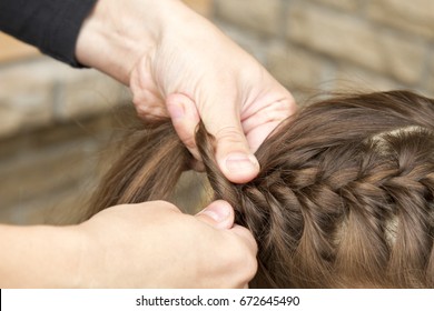 Mother Is Braiding Her Young Daughter's Hair