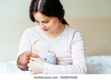 Mother Breastfeeding Baby Boy In Her Arms At Hospital. Mom Breast Feeding Her Newborn Child. Infant Eating Mother's Milk. Young Woman Nursing Her Baby. Concept Of Lactation Infant.