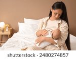 Mother breastfeeding her baby in bedroom