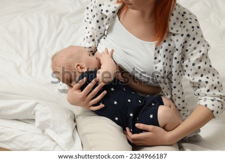 Mother breastfeeding her baby on bed, closeup