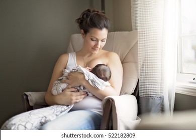 A Mother breastfeeding her little baby boy in her arms.