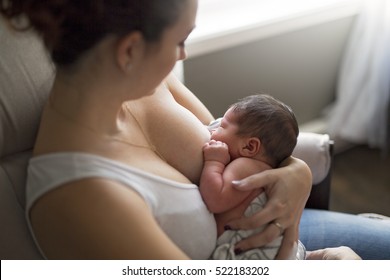 A Mother breastfeeding her little baby boy in her arms.