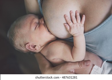 Mother breastfeeding her newborn baby boy. Mom nursing and feeding small kid.