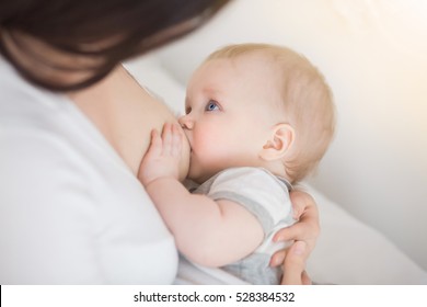 mother breastfeeding and hugging baby. Young mom breast feeding her newborn child. Lactation infant concept. Baby eating milk before he sleeping. Mother feed her six month baby son with breast milk