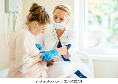 Mother breastfeeding newborn baby in hospital ward. Breastfeeding consultant help her. - Shutterstock ID 2140422701
