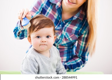 Mother Brushing Hair Of Her Baby Boy