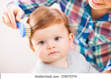 Mother Brushing Hair Of Her Baby Boy