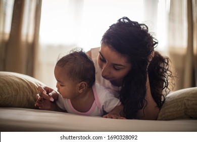 The mother cannot replace anything. African American mother with her daughter on bed.