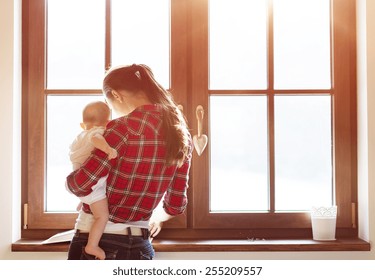 Mother carrying her little baby girl in her arms. - Powered by Shutterstock