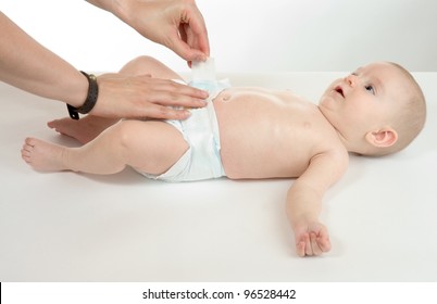 mother changes the diaper of her son
