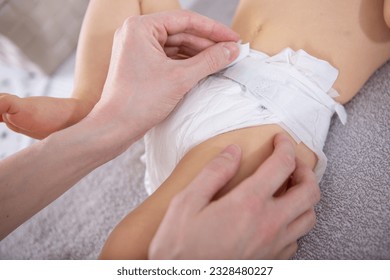 a mother changing baby diaper - Powered by Shutterstock