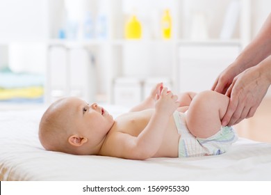 Mother changing the baby nappy in nursery