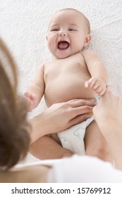 Mother Changing Baby's Diaper Indoors