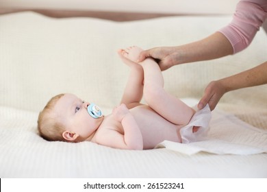 Mother changing a diaper to little baby girl