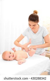 Mother Changing Diaper To Little Baby In Room