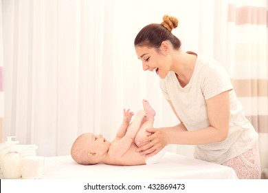 Mother Changing Diaper To Little Baby In Room