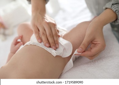 Mother changing her baby's diaper on table, closeup