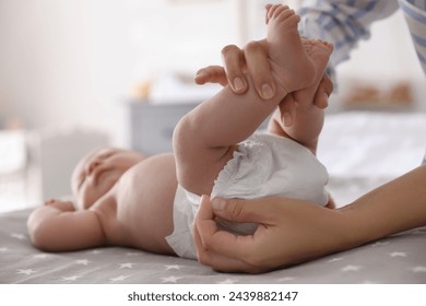 Mother changing her baby's diaper on bed - Powered by Shutterstock