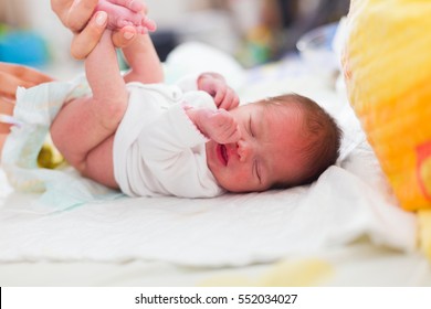 Mother Changing Little Newborn Girl's Diapers.