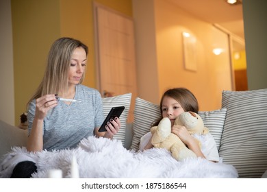 Mother Check Child Temperature And Holds Phone To Call The Doctor.