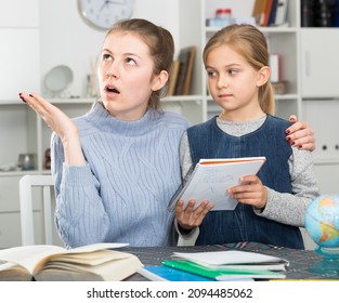 Mother Checks School Assignments Little Daughter. High Quality Photo
