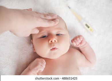 Mother Checks The Temperature Of A Sick Baby