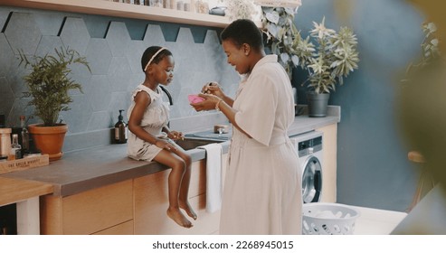 Mother, child and breakfast with mom feeding girl food for nutrition, growth health and wellness in home kitchen. Black woman with girl at family house for quality time, love and eating healthy - Powered by Shutterstock