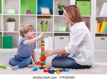 Mother and child build toy tower succes - Shutterstock ID 179320583