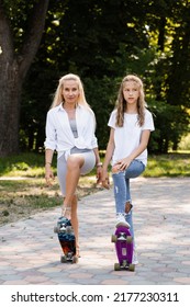 Mother And Child Daughter With Skate And Penny Board In Skate Park. Extreme Lifestyle. Family Of Mom And Her Kid Spend Time Together