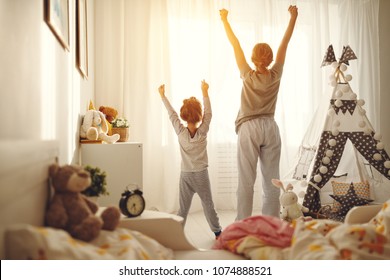 Mother And Child Daughter Stretch Themselves After Waking Up In The Morning
