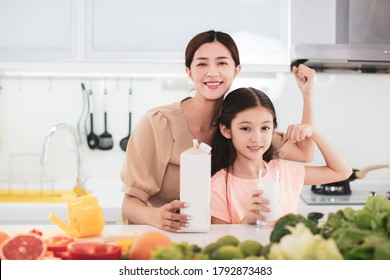 Mother And Child Drinking Milk At The Kitchen