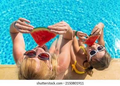 Mother and child eat watermelon near the pool. Selective focus. Food. - Powered by Shutterstock