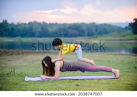 Mother and child enjoying relaxing yoga outdoors in the park.