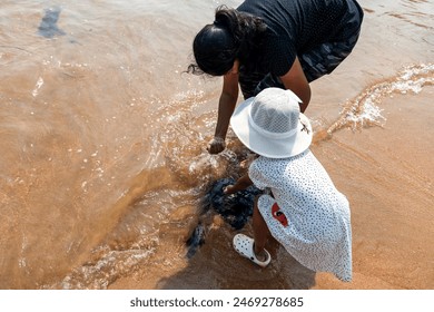 mother and child explore rocky beach, uncovering nature’s hidden gems - Powered by Shutterstock