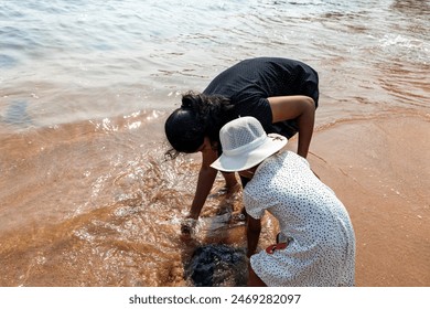 mother and child explore rocky beach, uncovering nature’s hidden gems - Powered by Shutterstock