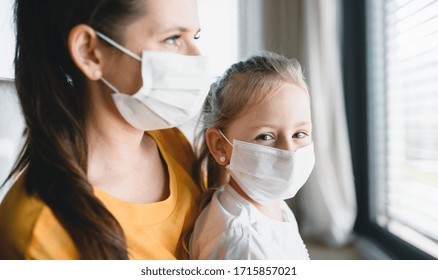 Mother And Child With Face Mask Indoors At Home, Corona Virus And Quarantine Concept.