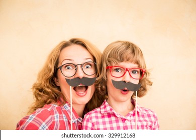 Mother And Child With Fake Mustache. Happy Family Playing In Home 